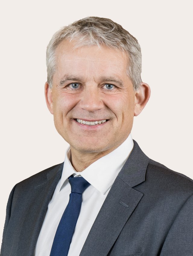 Ein Foto von Beat Jans vor beigem Hintergrund.